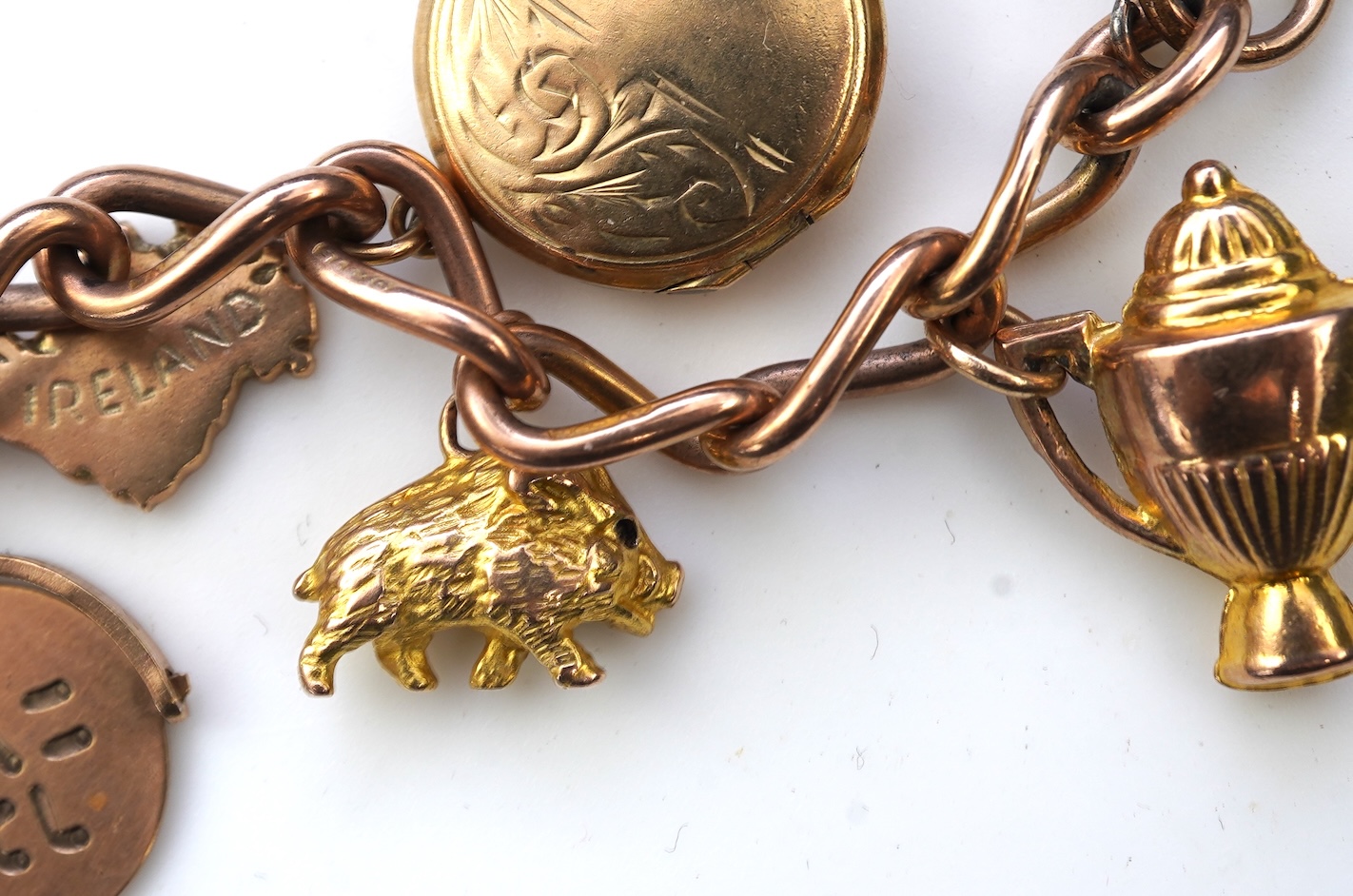 A gold charm bracelet, mid 20th century